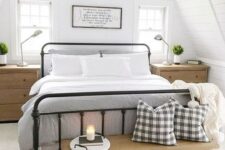 a chic modern farmhouse bedroom with white walls, a forged bed, wooden furniture and touches of plaid here and there