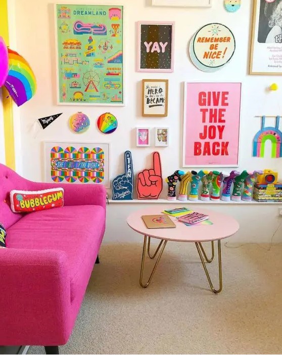 a colorful living room with a hot pink sofa, a blush table, a colorful gallery wall and a rainbow decoration is pure fun