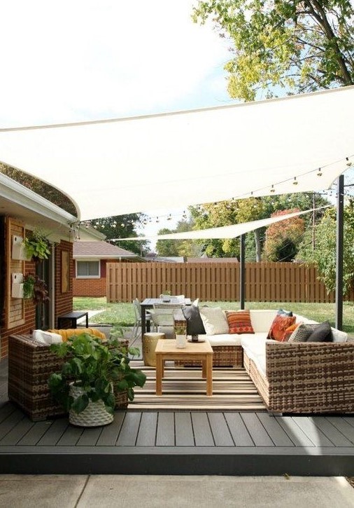 a contemporary rustic patio with woven furniture, bright and striped textiles, potted plants and coffee tables