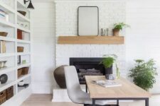 a cool modern country home office with a white brick fireplace, a large storage unit, a desk and a bold rug, potted plants