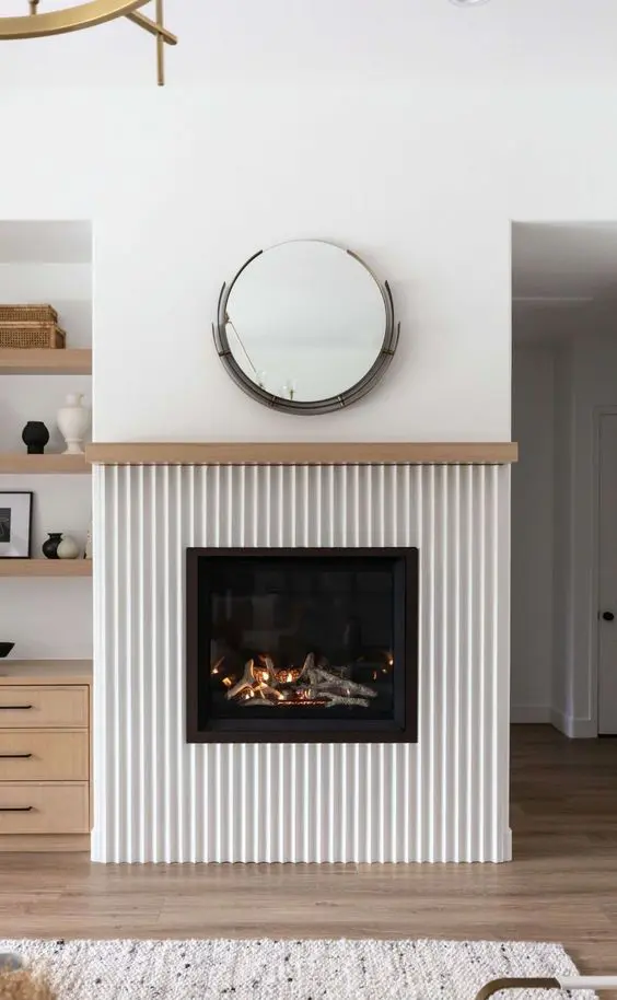 a faux fireplace with firewood and lights and a cool reeded surround is a lovely idea for a modern interior
