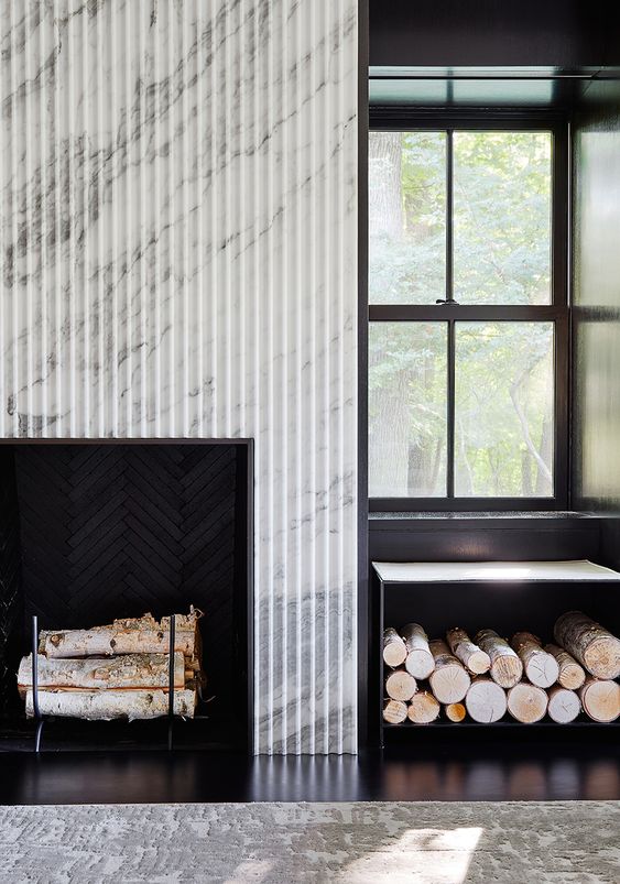 a fireplace with a fluted marble surroun and a firewood stand are perfect for a modern or contemporary space