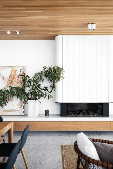 a fireplace with a white reeded surround and a storage panel underneath is a stylish and cool solution for a modern home