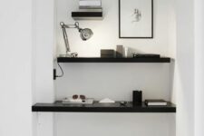 a minimalist niche with a built-in shelf and desk, a table lamp, some laconic decor and a black stool