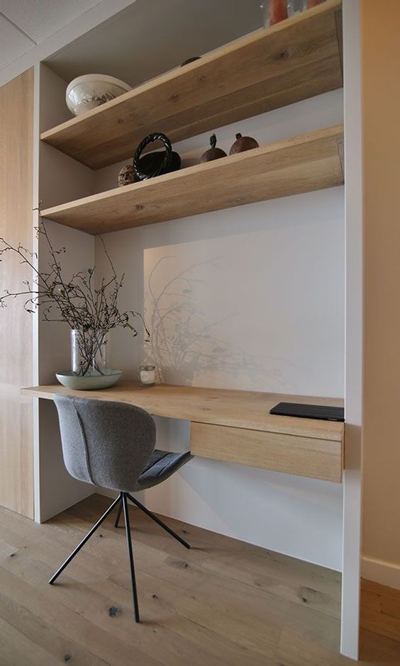 a minimalist niche with built-in shelves and a desk, a grey chair and some decor is a lovely idea for a minimal space