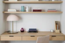 a minimalist niche with built-in shelves and a desk with drawers, a neutral chair,  a table lamp and some books