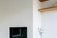 a minimalist space with a fireplace and a fluted panel on top is a stylish idea for a modern living room
