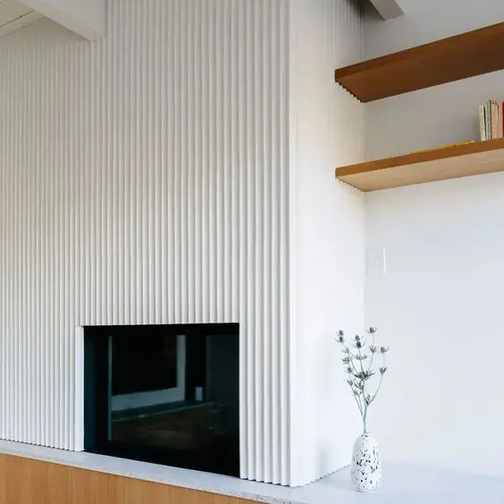 a minimalist space with a fireplace and a fluted panel on top is a stylish idea for a modern living room