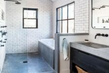 a modern farmhouse bathroom with white tiles, wooden floors, a dark vanity and some concrete