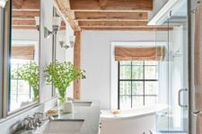 a modern farmhouse bathroom with wooden beams and a matching vanity, a shower space, a free-standing tub and mirrors