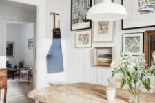 a modern farmhouse dining room with a chic wooden dining set, a gallery wall and simple white lamps
