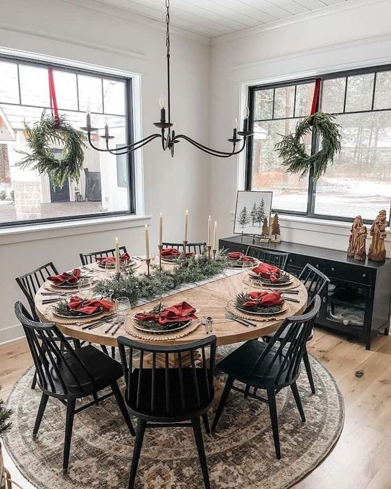 a modern farmhouse dining space with a black credenza, a stained table and black chairs, lovely Christmas decor