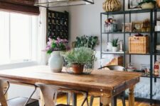 a modern farmhouse dining space with open shelving, a stained vintage table, metal chairs, a pendant lamp and some decor
