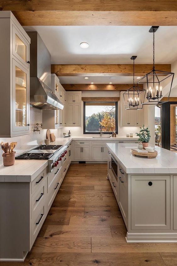 a modern farmhouse dove grey kitchen with stone countertops, wooden beams on the ceiling and catchy pendant lamps