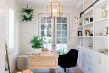 a modern farmhouse home office with a large white storage unit, a stained desk, a black chair, a fluffy stool and some potted greenery