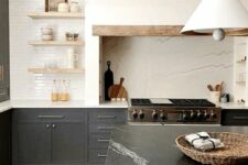 a modern farmhouse kitchen with soot cabinets, a large white hood, open shelves, a kitchen island with a stone countertop