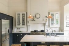 a modern farmhouse kitchen with white and graphite grey cabinets, white stone countertops, pendant lamps and wooden stools