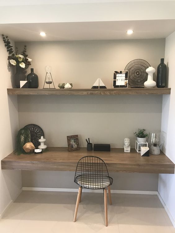 A modern farmhouse niche with a built in shelf and desk, with decor and potted plants, a cool chair and built in lights