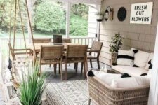 a modern farmhouse terrace with wicker and wood furniture, a suspended daybed, neutral textiles and potted plants