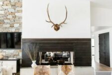 a modern rustic space with jute, fur, wood and stone in decor plus cowhide chairs