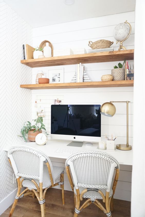 A niche with shiplap, built in stained shelves and a desk, some rattan chairs, some decor and greenery is a cozy farmhouse space