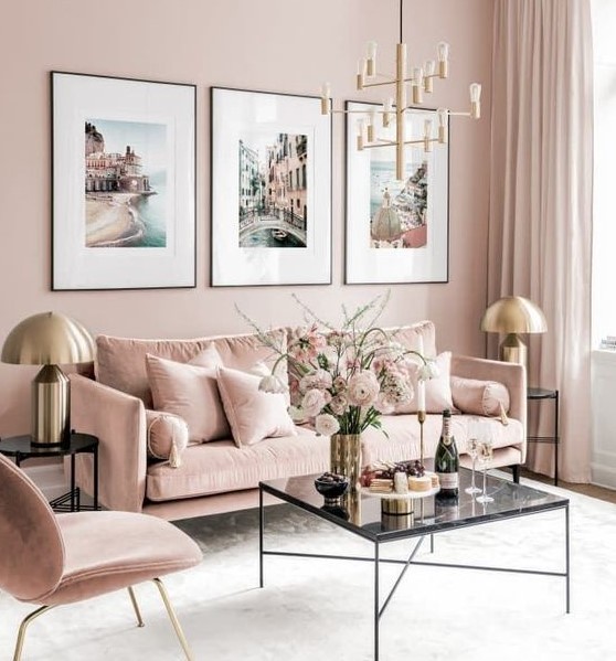 a refined living room with blush walls, blush furniture, a chic gallery wall and touches of gold for glam