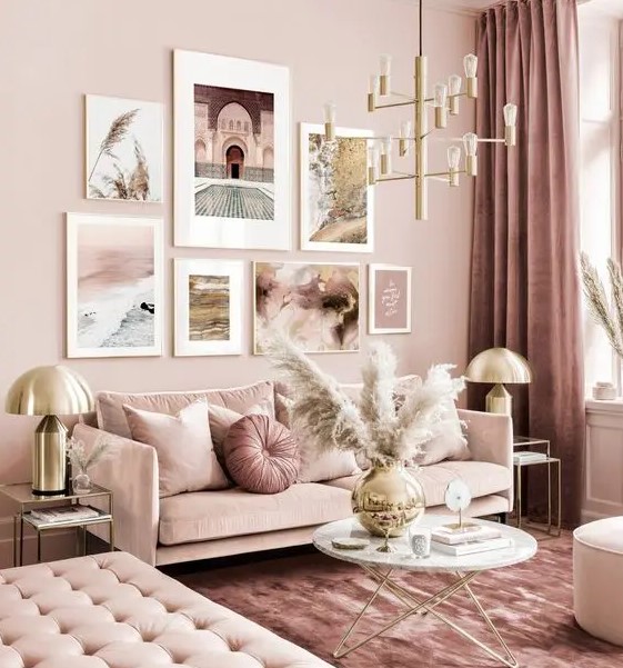 a refined monochromatic pink living room with elegant furniture, a gold chandelier, pampas grass and a cool gallery wall