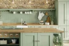 a sage green farmhouse kitchen with a beadboard backsplash and butcherblock countertops, a large kitchen island with storage compartments