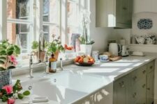 a sage green farmhouse kitchen with white stone countertops, a single upper cabinet, vintage fixtures and a vintage sink