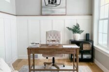 a serene modern farmhouse home office with paneled walls, a stained desk, a greige chair and a loveseat, a frame pendant lamp