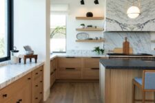 a stylish modern farmhouse kitchen with stained lower cabinets, a large kitchen island, marble countertops and a backsplash