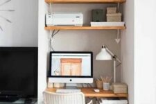 a tiny awkward nook space taken by a built-in working space – a desk, some shelves and a white office chair plus a white table lamp