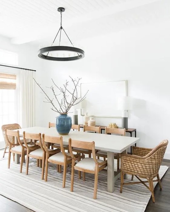a welcoming modern farmhouse dining room with a console, a pendant black lamp, a long table, wooden and woven chairs