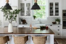 a white modern farmhouse kitchen with shaker cabinets, a white subway tile backsplash, a kitchen island and woven stools