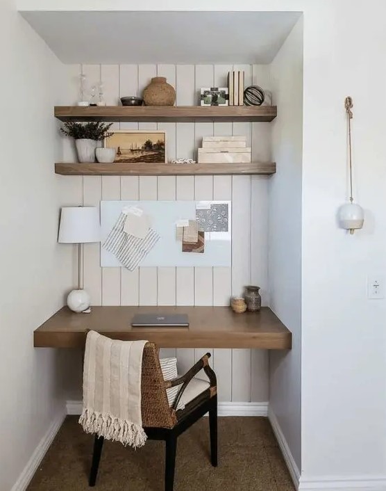 an awkward nook turned into a small working space, with built-in shelves and a desk, a woven chair and various decor is cool