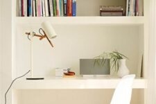 modern niche with shelves and a desk, books, a table lamp, some greenery and boxes for storage, a white chair