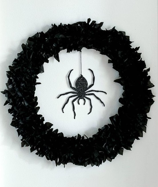 a black faux flower wreath and a black glitter spider is a stunning solution for decorating your front door and it looks elegant