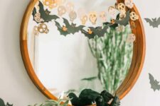 02 simple and quick Halloween mirror decor with a bat and a skull garland is a cool last-minute solution