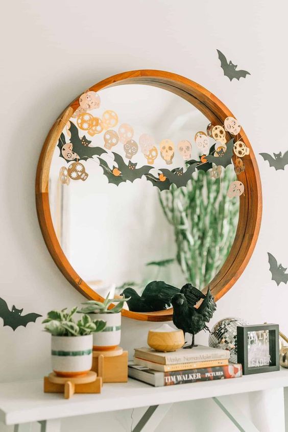 Simple and quick Halloween mirror decor with a bat and a skull garland is a cool last minute solution