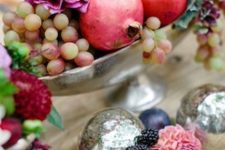 03 a beautiful fall centerpiece of grapes, bold blooms and pomegranates is a catchy idea for your party