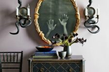 03 a gold frame mirror with ghost hands and snake decorated wall sconces are a cool combo for Halloween