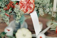 04 a beautiful fall centerpiece of seeded eucalyptus, pomegranates, ribbons and berries is a stylish idea to realize