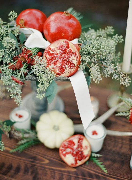 a beautiful fall centerpiece of seeded eucalyptus, pomegranates, ribbons and berries is a stylish idea to realize