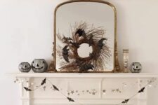 04 a chic vintage mirror in a gilded frame, with a twig wreath with black bats is a cool and easy to make decoration