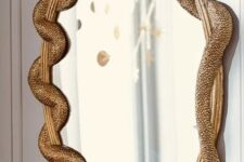 04 a mirror in a gilded frame with gold snakes is a chic and refined decor idea for Halloween