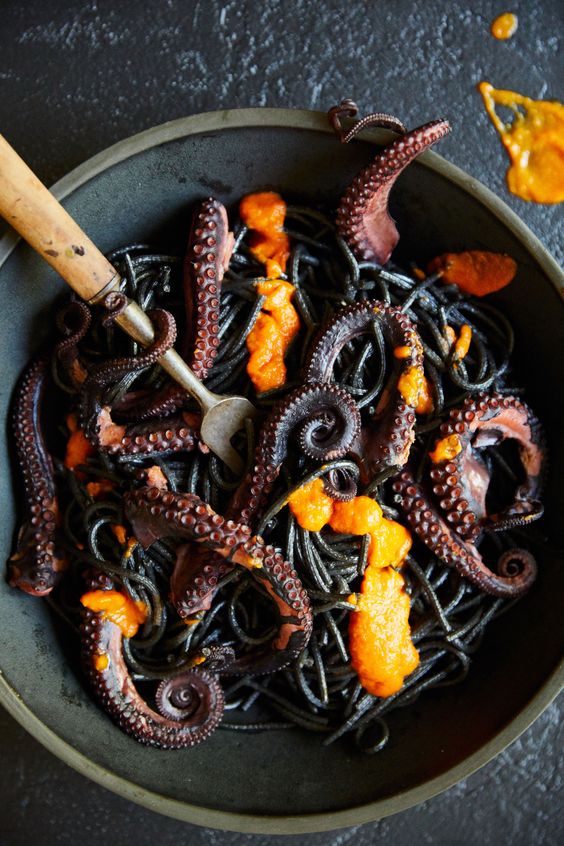 black pasta with octopus and some bright sauce is a gorgeous idea for an adult Halloween party