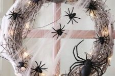 05 a bold and pretty Halloween wreath of whitewashed vine, LED lights, black spiders and a striped bow is a lovely idea to go for