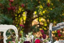 05 a bold fall or Thanksgiving centerpiece of red, burgundy blooms and greenery and pomegranates on the table is amazing
