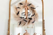 06 a mirror in a vintage frame, with a pampas grass wreath, a ribbon and black bats is a cool idea for Halloween
