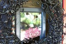 07 a black vine Halloween wreath covered with snakes, spiders and insects of all kinds is a lovely idea to style your front door